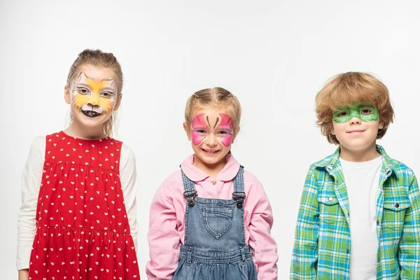 Amici sorridenti con dipinti facciali colorati guardando la fotocamera isolata sul bianco — Foto stock