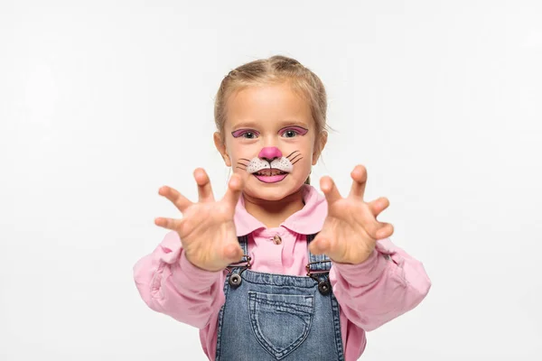 Cute kid with cat muzzle painting on face showing frightening gesture while looking at camera isolated on white — Stock Photo