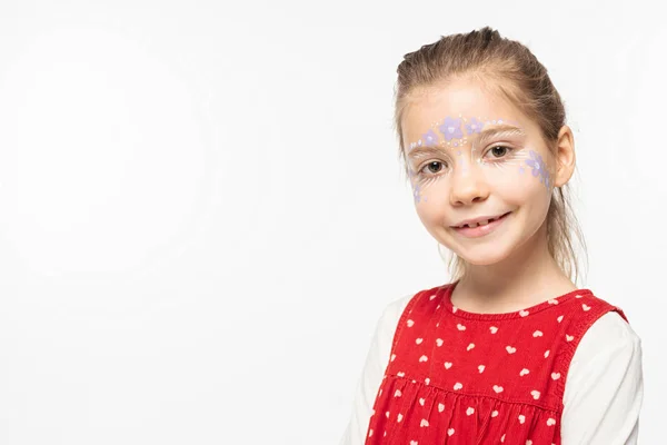 Enfant souriant avec peinture florale sur le visage en regardant la caméra isolée sur blanc — Photo de stock