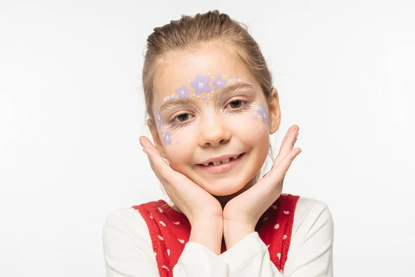 Niedliches Kind mit floraler Bemalung im Gesicht, das in die Kamera lächelt, isoliert auf Weiß — Stockfoto