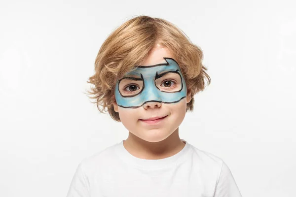 Очаровательный мальчик в маске супергероя нарисованный на лице улыбаясь в камеру изолированы на белом — стоковое фото