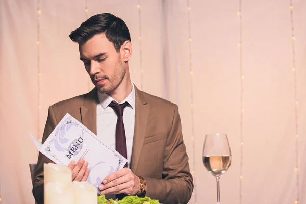 Bonito, elegante homem ler menu enquanto sentado no restaurante — Fotografia de Stock