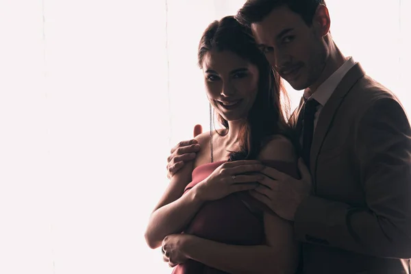 Glücklicher, eleganter Mann und Frau, die sich umarmen und an Valentinstagen in die Kamera schauen — Stockfoto