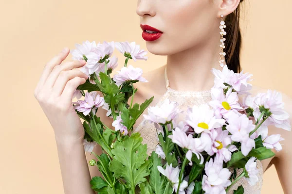 Vista ritagliata di giovane donna che tiene fiori in fiore isolati su beige — Foto stock