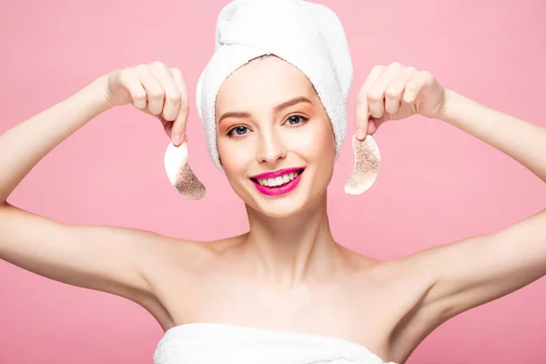 Sorridente giovane donna in asciugamano in possesso di macchie oculari isolate su rosa — Foto stock