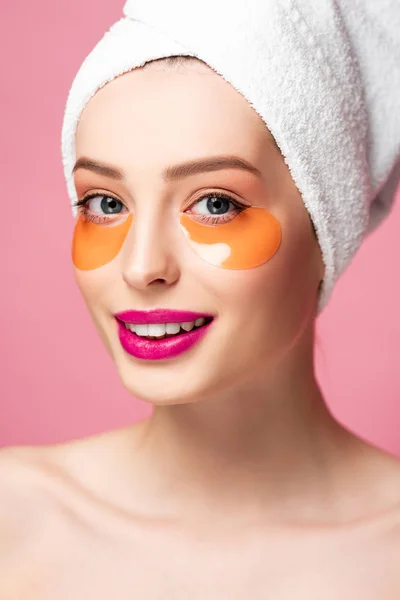 Lächelndes nacktes Mädchen mit Augenklappen im Gesicht, das in die Kamera schaut, isoliert auf rosa — Stockfoto