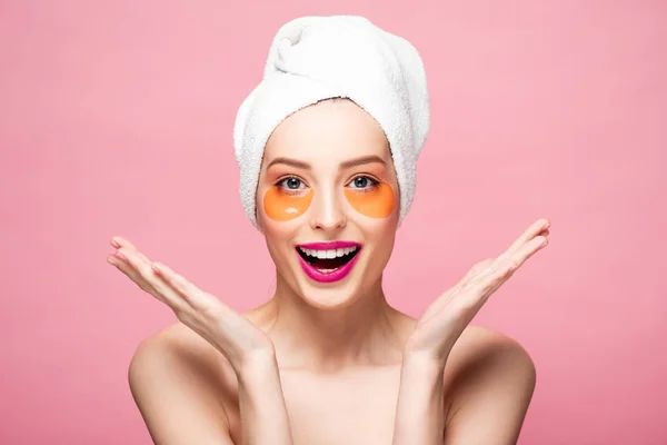 Excited girl with eye patches on face looking at camera isolated on pink — Stock Photo