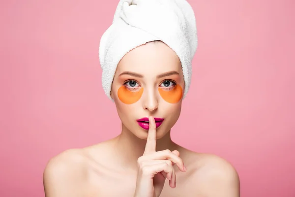 Pretty naked girl with eye patches showing hush sign isolated on pink — Stock Photo