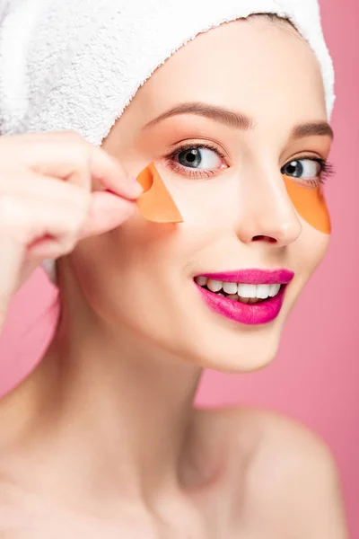 Nackte Mädchen berühren Augenklappe und Blick auf Kamera isoliert auf rosa — Stockfoto