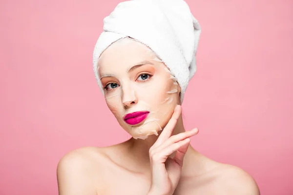 Naked woman in moisturizing mask touching face isolated on pink — Stock Photo