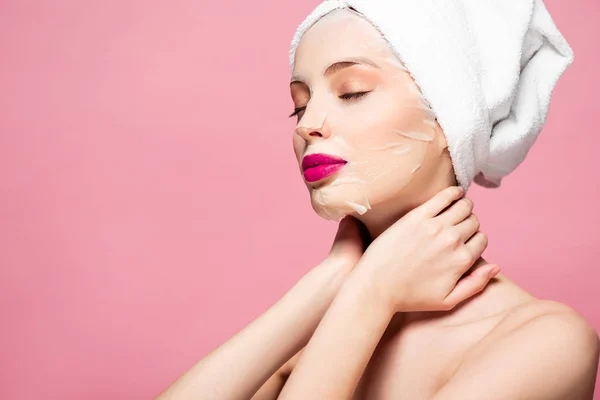 Mujer joven en mascarilla hidratante con los ojos cerrados aislados en rosa - foto de stock