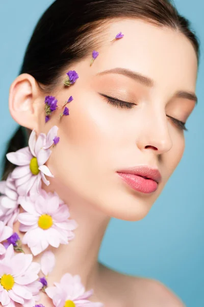 Жінка з квітами і закритими очима ізольована на синьому — стокове фото