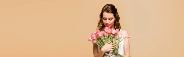 Panoramic shot of happy girl holding pink tulips isolated on pink — Stock Photo