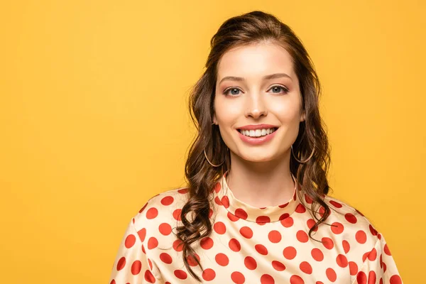 Glückliche junge Frau lächelt, während sie in die Kamera schaut, isoliert auf gelb — Stockfoto