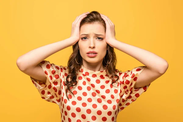 Erschöpfte junge Frau berührt Kopf und leidet an Kopfschmerzen isoliert auf gelb — Stockfoto