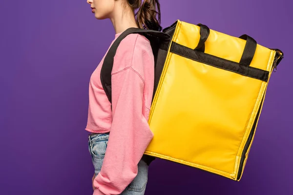 Cropped view of courier carrying thermo box isolated on purple — Stock Photo