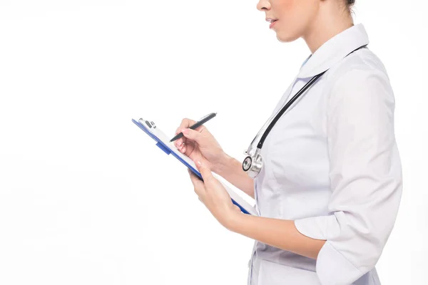 Vue recadrée du médecin avec stéthoscope écrit sur presse-papiers isolé sur blanc — Photo de stock