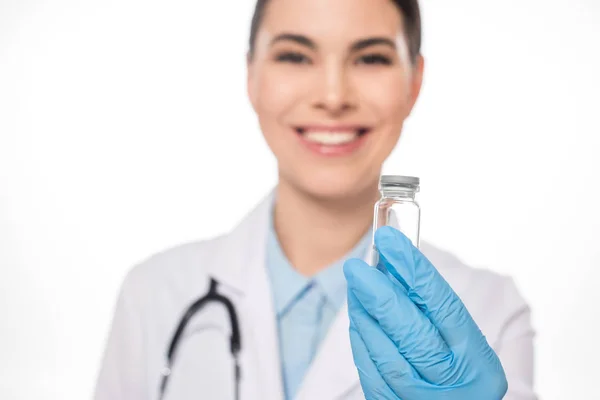Focus selettivo del medico sorridente che tiene il vaso con il vaccino isolato sul bianco — Foto stock