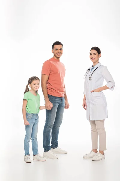 Full length of pediatrician near father with daughter smiling at camera on white background — Stock Photo