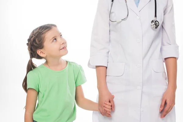 Bambino sorridente che si tiene per mano con pediatra femminile isolato su bianco — Foto stock