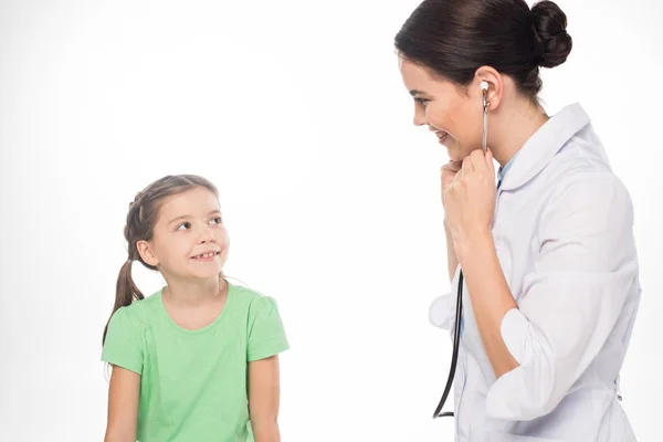 Lächelndes Kind beim Kinderarzt mit Stethoskop isoliert auf Weiß — Stockfoto