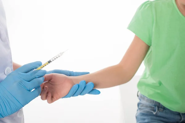 Обрезанный вид педиатра, делающего инъекцию вакцины ребенку, изолированному на белом — стоковое фото
