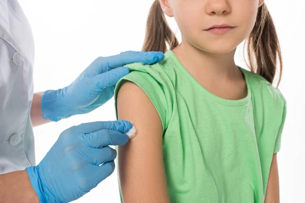 Cropped view of pediatrician with cotton wool rubbing child shoulder isolated on white — Stock Photo