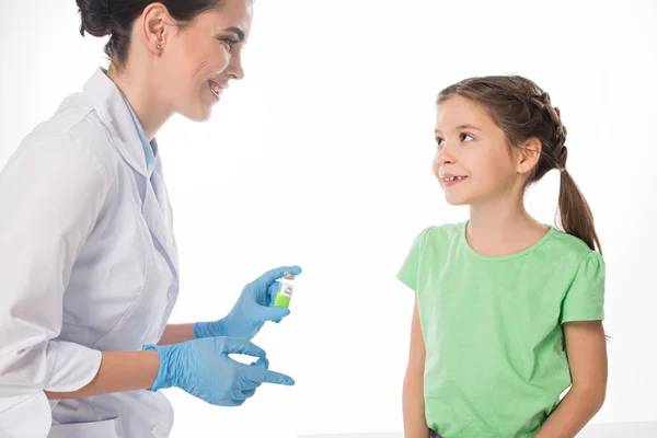 Smiling pediatrician with hpv vaccine looking at kid isolated on white — Stock Photo