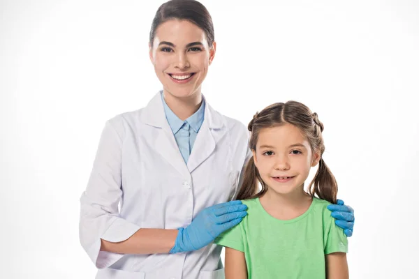 Pediatrician hugging kid and smiling at camera isolated on white — Stock Photo