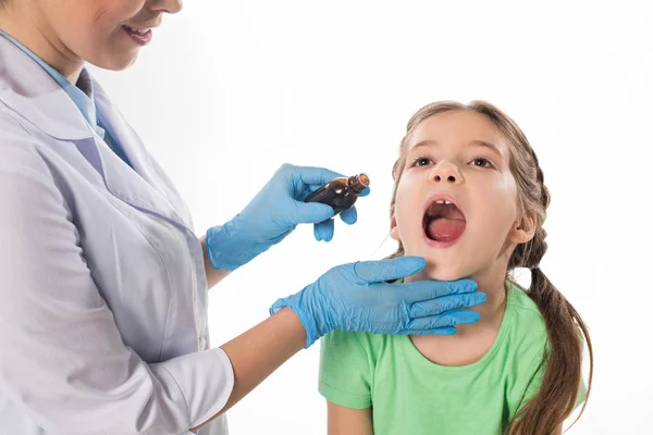 Pediatra sonriente dando mezcla a niño aislado en blanco - foto de stock