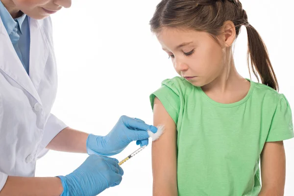 Pediatra que administra la vacuna inyectable a un niño aislado en blanco - foto de stock