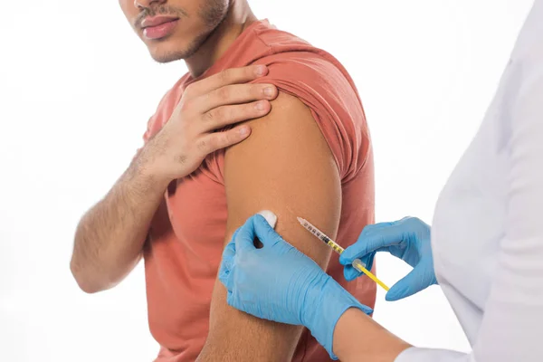 Vista recortada del médico que realiza la inyección de vacuna al paciente aislado en blanco - foto de stock