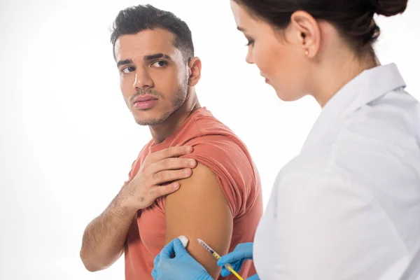 Vista laterale del paziente che guarda il medico con cotone idrofilo e siringa isolati su bianco — Foto stock