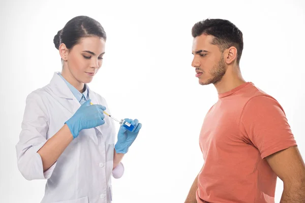 Side view of doctor picking up flu vaccine near patient isolated on white — Stock Photo