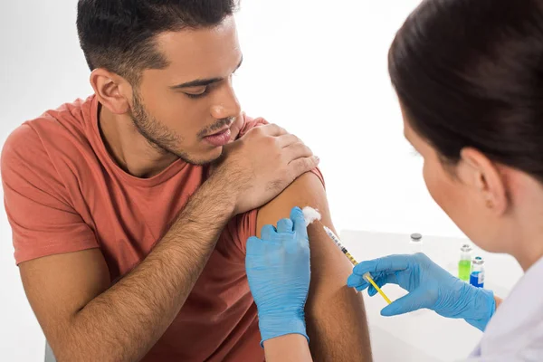 Selektiver Fokus des Arztes bei der Injektion eines hübschen Patienten, der auf Weiß isoliert ist — Stockfoto