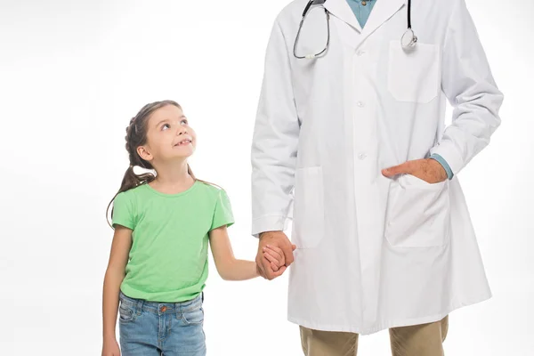 Усміхнена дитина тримає руку педіатра ізольовано на білому — стокове фото