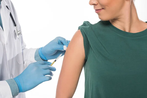 Vista ritagliata del medico che fa l'iniezione del vaccino al paziente isolato su bianco — Foto stock