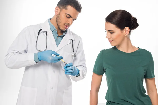 Médico pegando vacina em seringa perto do paciente isolado em branco — Fotografia de Stock