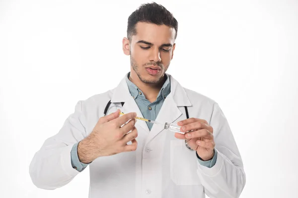 Beau médecin avec stéthoscope ramassant le vaccin en seringue isolée sur blanc — Photo de stock