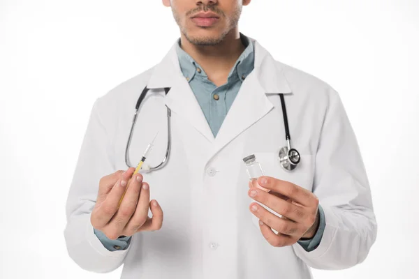 Vista recortada del médico que sostiene la jeringa y el frasco con la vacuna aislada en blanco - foto de stock