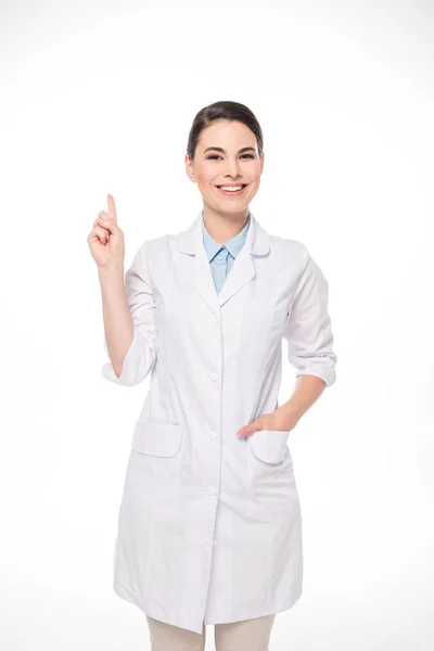 Hermoso médico sonriendo a la cámara y señalando con el dedo aislado en blanco - foto de stock