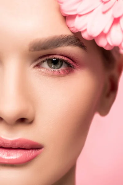 Close up view of face of girl with pink gerbera flower, isolated on pink — Stock Photo