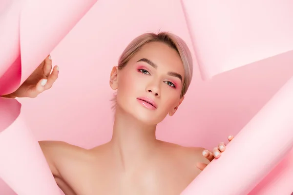 Bela menina nua com maquiagem rosa em papel rasgado, isolado em rosa — Fotografia de Stock