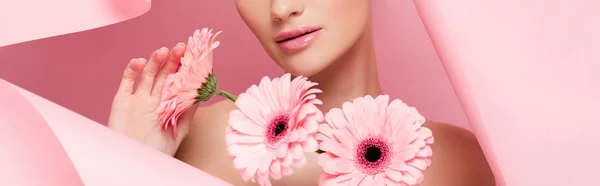 Vista recortada de chica desnuda con flores de color rosa en papel roto, en rosa, plano panorámico - foto de stock