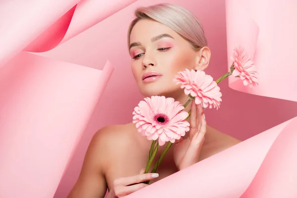 Menina nua com flores rosa e maquiagem em papel rasgado, em rosa — Fotografia de Stock