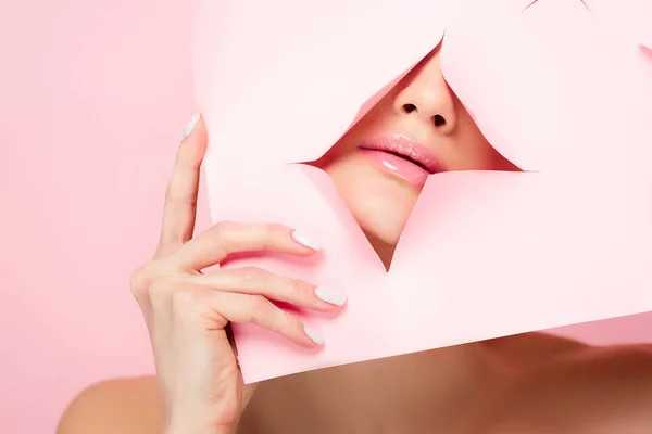 Hermosa chica desnuda mostrando labios rosados en papel roto, aislado en rosa - foto de stock