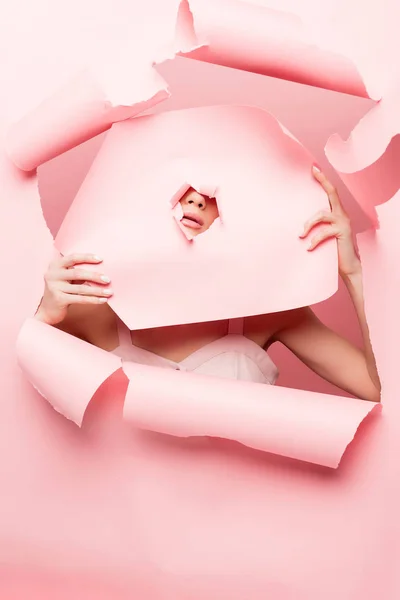 Modelo elegante posando com papel rasgado rosa, em rosa — Fotografia de Stock