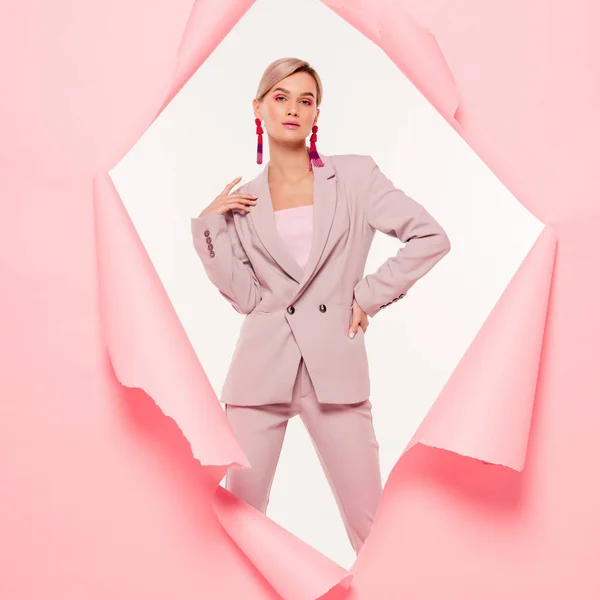 Fashionable woman in trendy suit posing in torn paper, isolated on white — Stock Photo