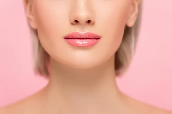 Vue recadrée de jeune femme à la peau parfaite et aux lèvres roses, isolée sur rose — Photo de stock