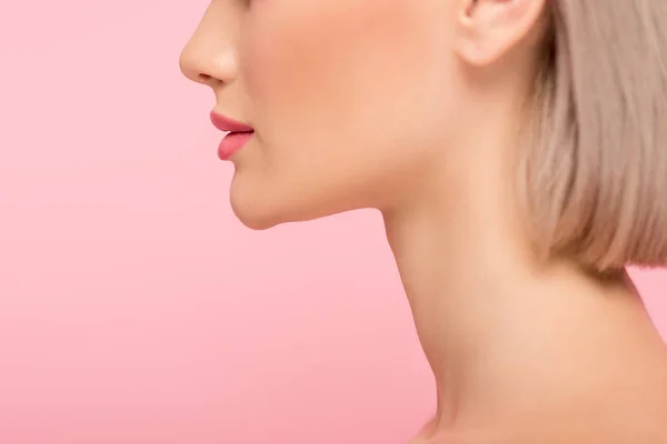 Vista recortada de la mujer con la cara perfecta y maquillaje rosa, aislado en rosa - foto de stock